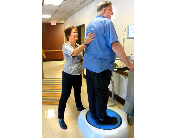 Karen Knoll, PTA, works with a patient, Paul C., using the dynamic plate system and the manufacturer’s recommended fall risk screening tool.