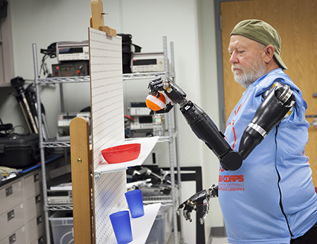 Bionic arms recipient Les Baugh completes a task showcasing his control of the modular prosthetic limbs. (Image courtesy of Johns Hopkins University Applied Physics Laboratory)